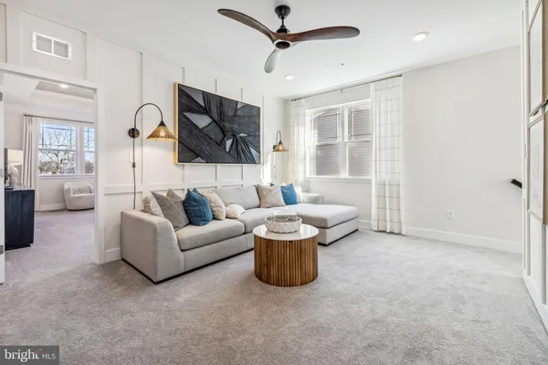 a living room with furniture a flat screen tv and a window