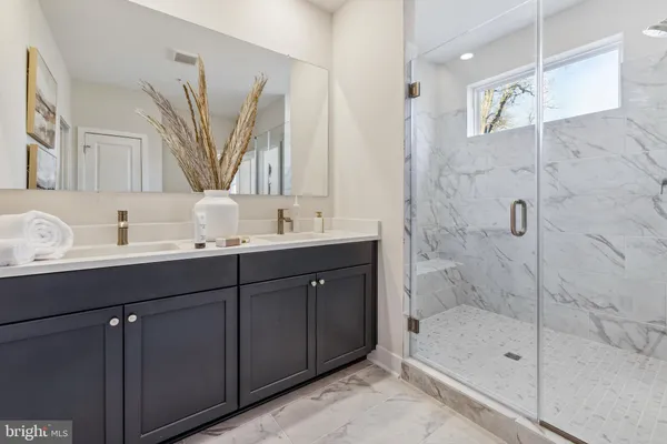 a bathroom with a double vanity sink mirror double and shower