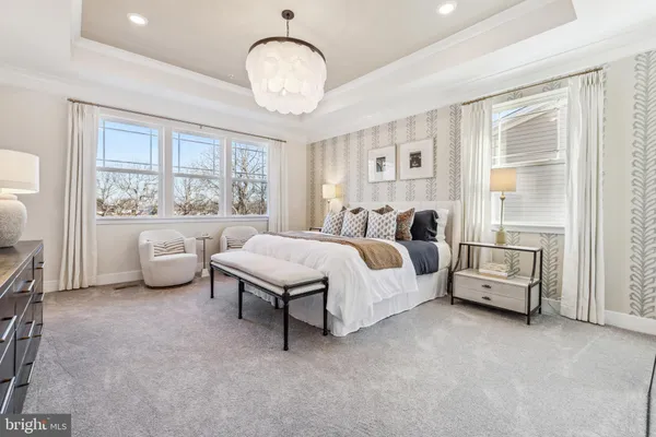 a spacious bedroom with a bed and a chandelier