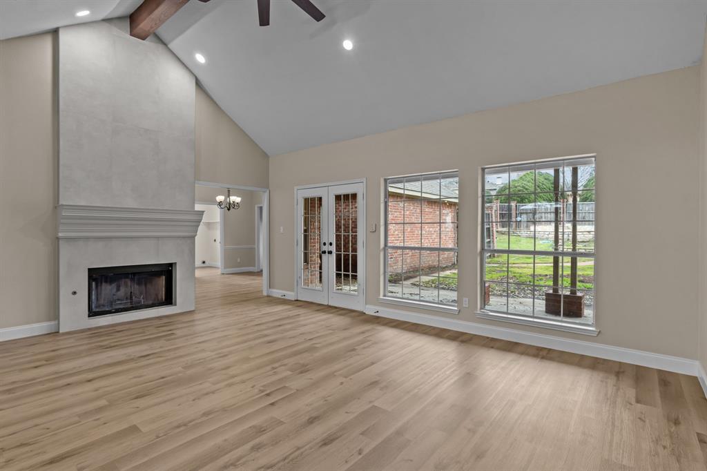 4510 Dexham Road Rowlett, TX 75088 - Photo 7 of 33 an empty room with wooden floor fireplace and windows