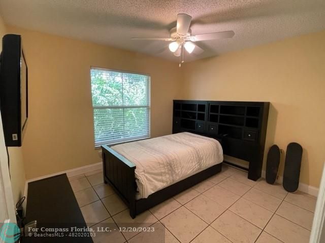 Keystone Lake Pembroke Pines, FL 33029 - Photo 22 of 23 a bedroom with a bed and a chandelier