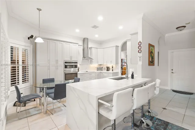 a large kitchen with kitchen island a large counter top space appliances and cabinets