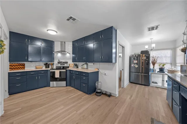 a kitchen with stainless steel appliances kitchen island granite countertop a refrigerator and a stove top oven