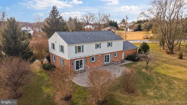 a aerial view of a house with yard and trees