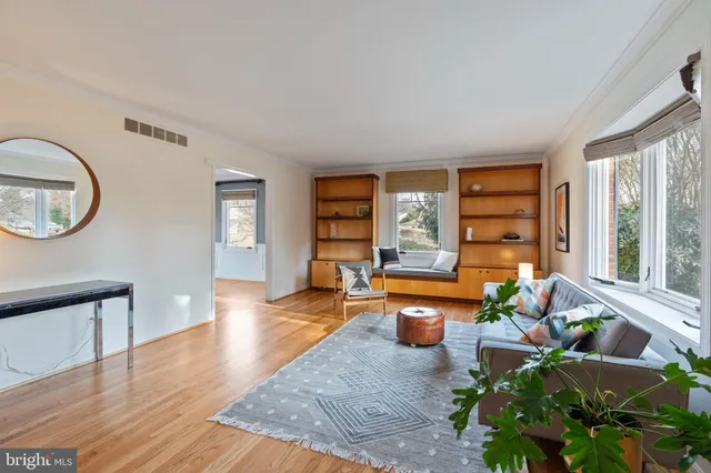 a living room with furniture floor to ceiling window and wooden floor