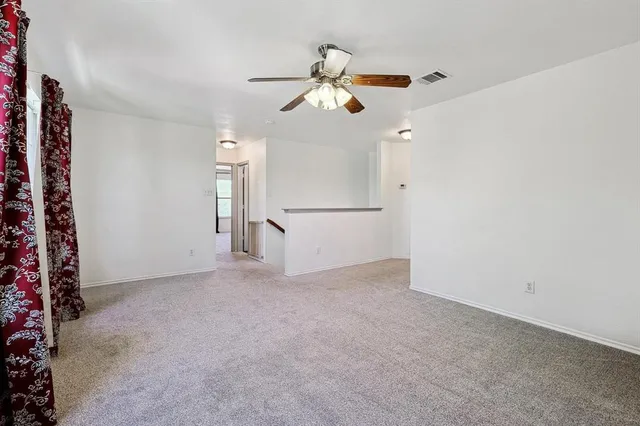 a view of empty room with ceiling fan