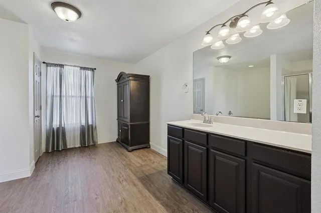 a bathroom with a double vanity sink mirror and shower