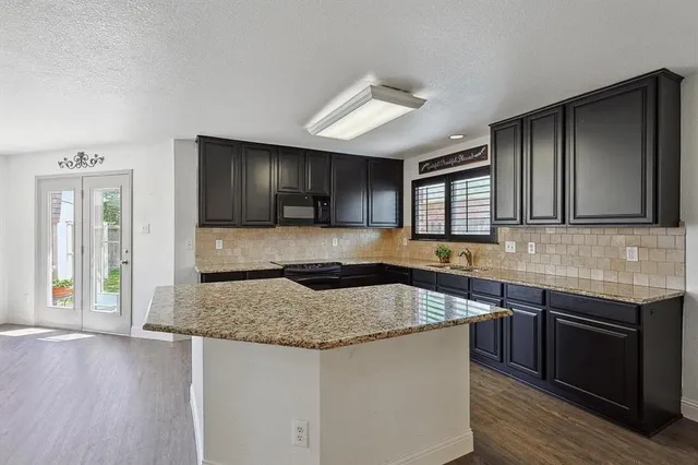 a kitchen with stainless steel appliances granite countertop wooden cabinets a sink and dishwasher