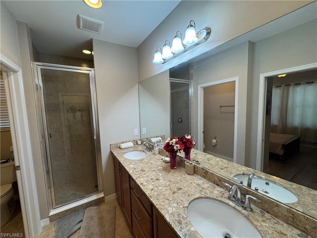 1431 Santiago Circle, Unit 1901 Naples, FL 34113 - Photo 13 of 29 a bathroom with a granite countertop double vanity sink and a mirror