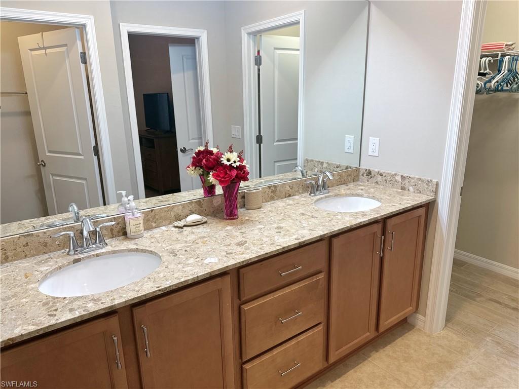 1431 Santiago Circle, Unit 1901 Naples, FL 34113 - Photo 14 of 29 a bathroom with a granite countertop sink and a mirror