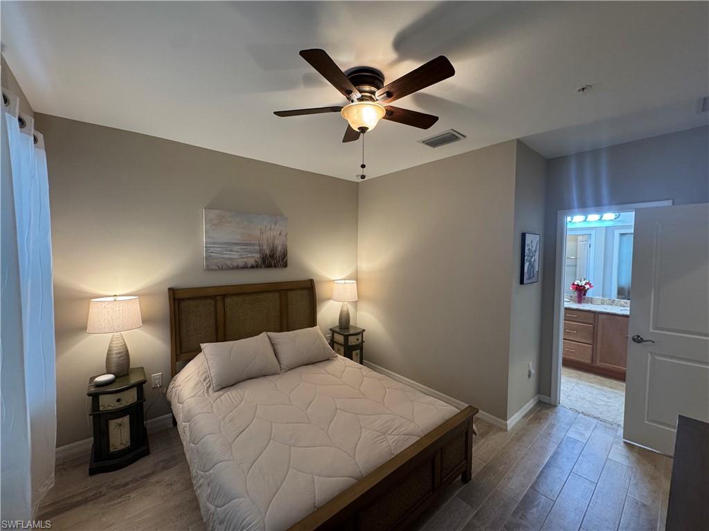 1431 Santiago Circle, Unit 1901 Naples, FL 34113 - Photo 17 of 29 a bed room with a bed and a ceiling fan