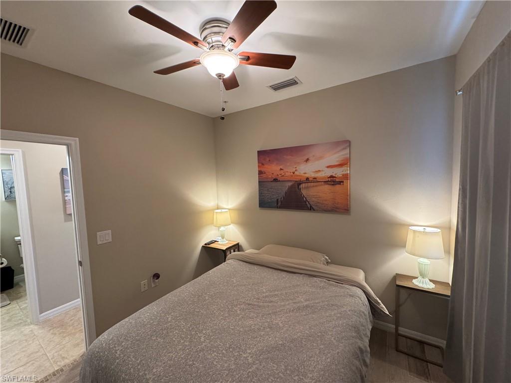 1431 Santiago Circle, Unit 1901 Naples, FL 34113 - Photo 18 of 29 a bedroom with a bed and a chandelier