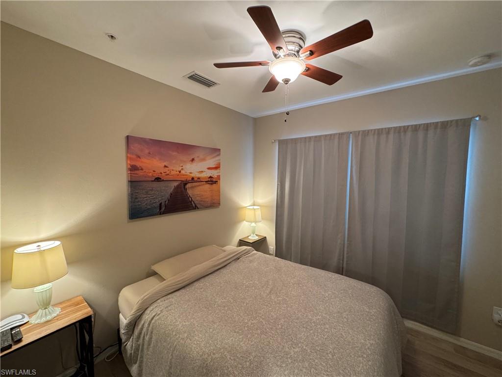 1431 Santiago Circle, Unit 1901 Naples, FL 34113 - Photo 19 of 29 a bedroom with a large bed and a chandelier