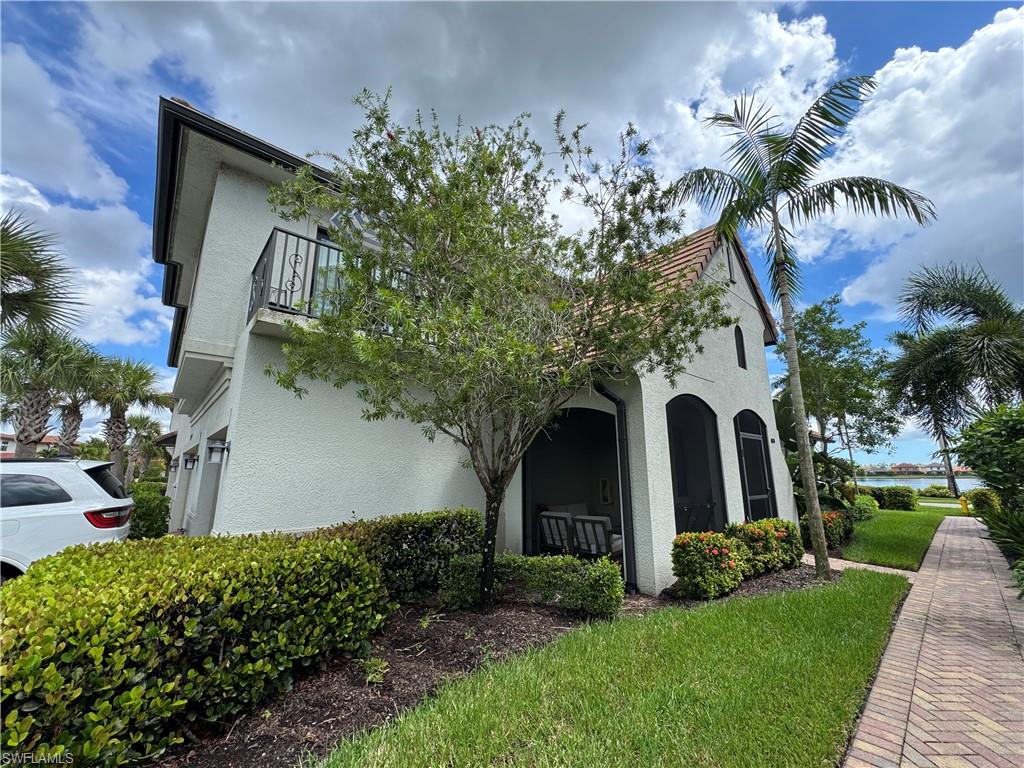 1431 Santiago Circle, Unit 1901 Naples, FL 34113 - Photo 2 of 29 a front view of a house with garden