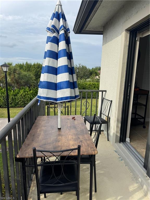 1431 Santiago Circle, Unit 1901 Naples, FL 34113 - Photo 26 of 29 a view of balcony with a dining table and chairs