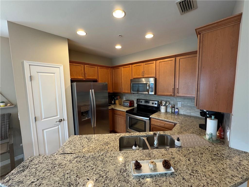 1431 Santiago Circle, Unit 1901 Naples, FL 34113 - Photo 5 of 29 a kitchen with refrigerator and chairs