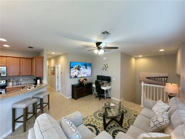 a living room with furniture a dining table and kitchen view