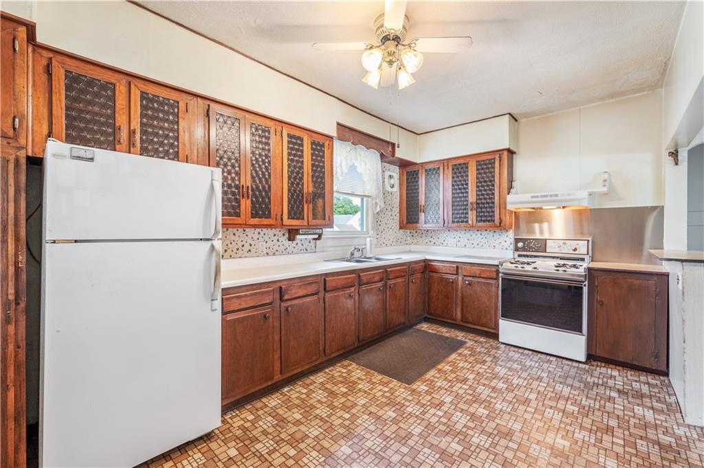 620 Virginia Avenue Rochester, PA 15074 - Photo 15 of 36 a kitchen with stainless steel appliances granite countertop a refrigerator a sink dishwasher a stove with wooden cabinets