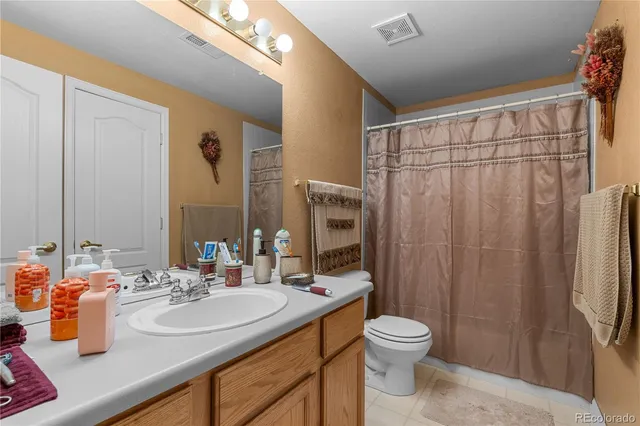a bathroom with a double vanity sink toilet and shower