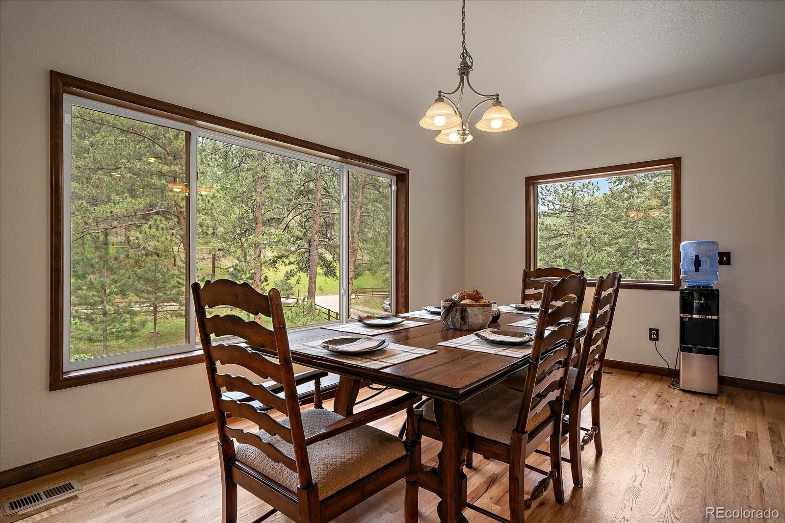 27756 Troublesome Gulch Road Evergreen, CO 80439 - Photo 14 of 47 a view of a dining room with furniture window and wooden floor