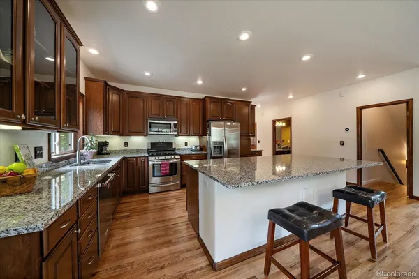 a kitchen with stainless steel appliances granite countertop sink stove top oven and microwave