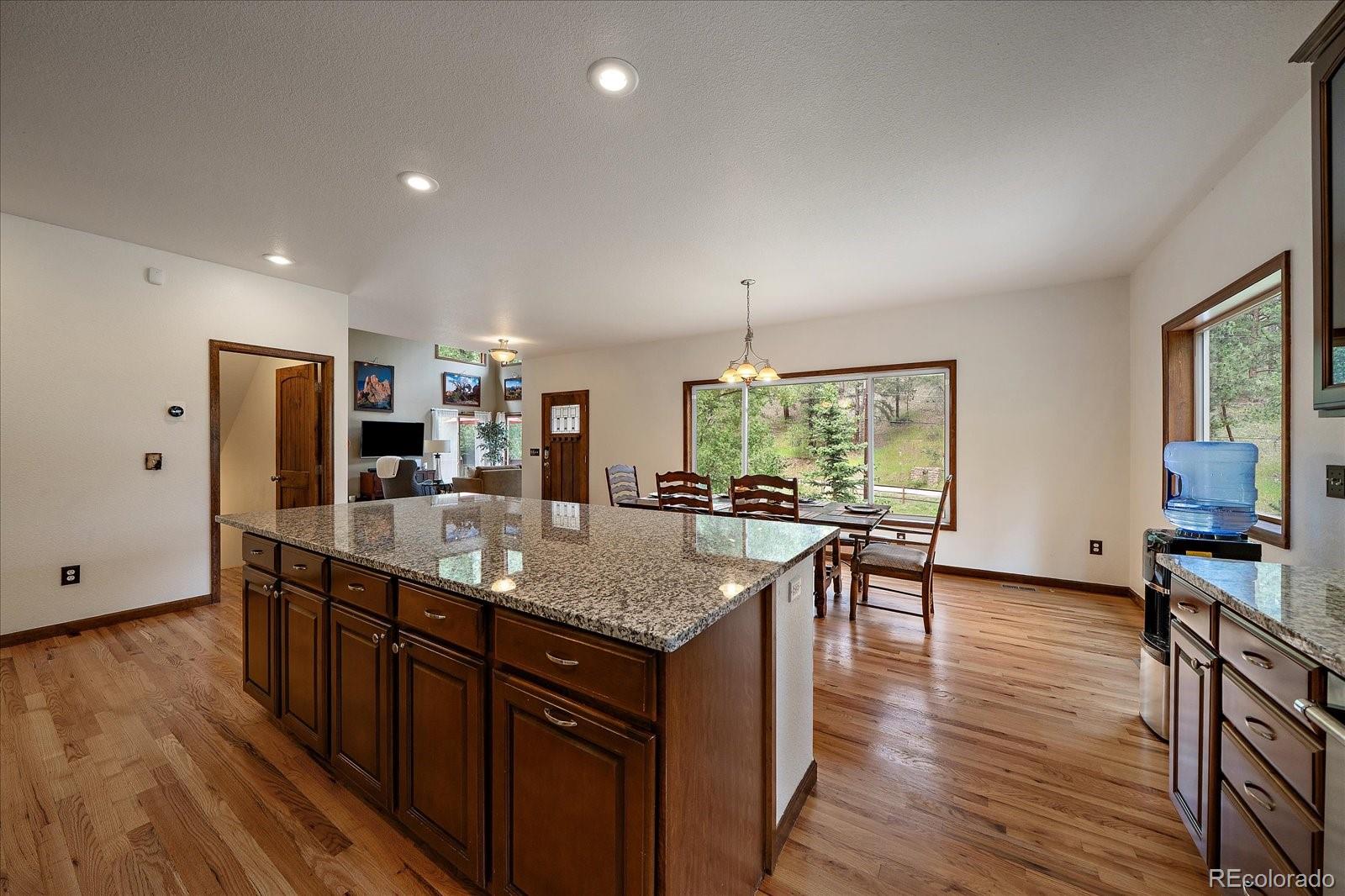 27756 Troublesome Gulch Road Evergreen, CO 80439 - Photo 18 of 47 a kitchen with stainless steel appliances granite countertop sink stove top oven and microwave
