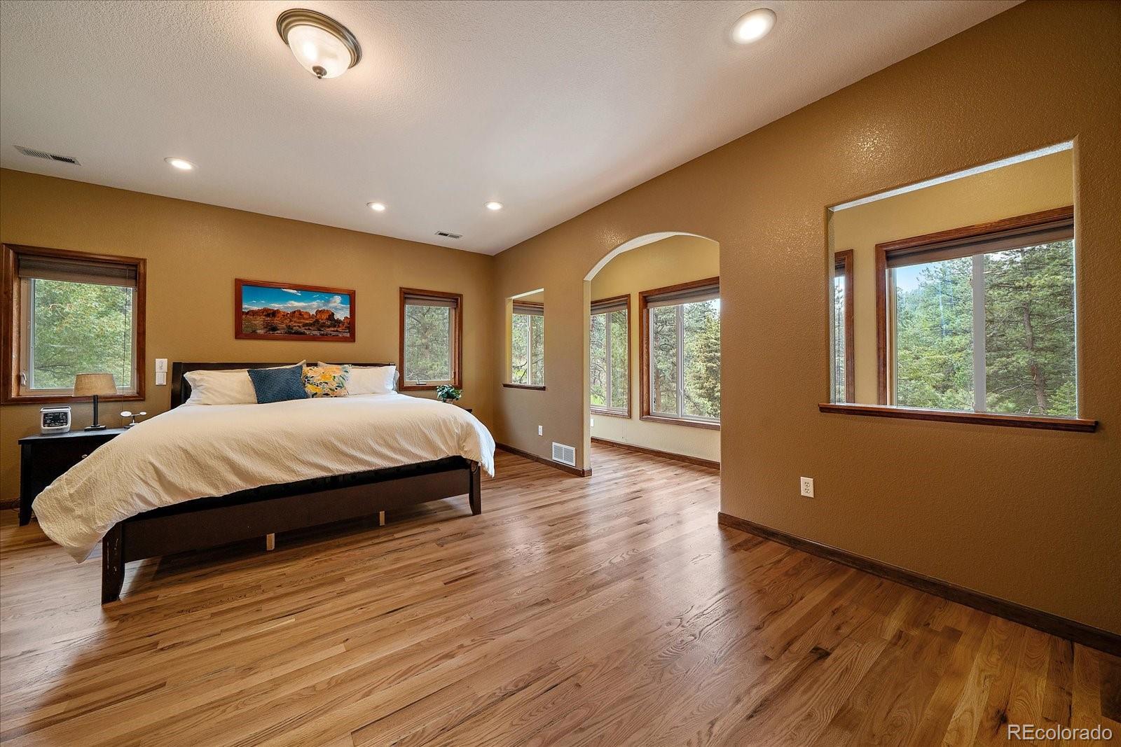 27756 Troublesome Gulch Road Evergreen, CO 80439 - Photo 26 of 47 a bedroom with a large bed and a large window