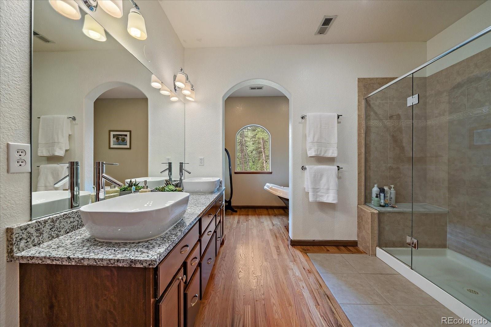 27756 Troublesome Gulch Road Evergreen, CO 80439 - Photo 27 of 47 a spacious bathroom with a granite countertop sink mirror and shower