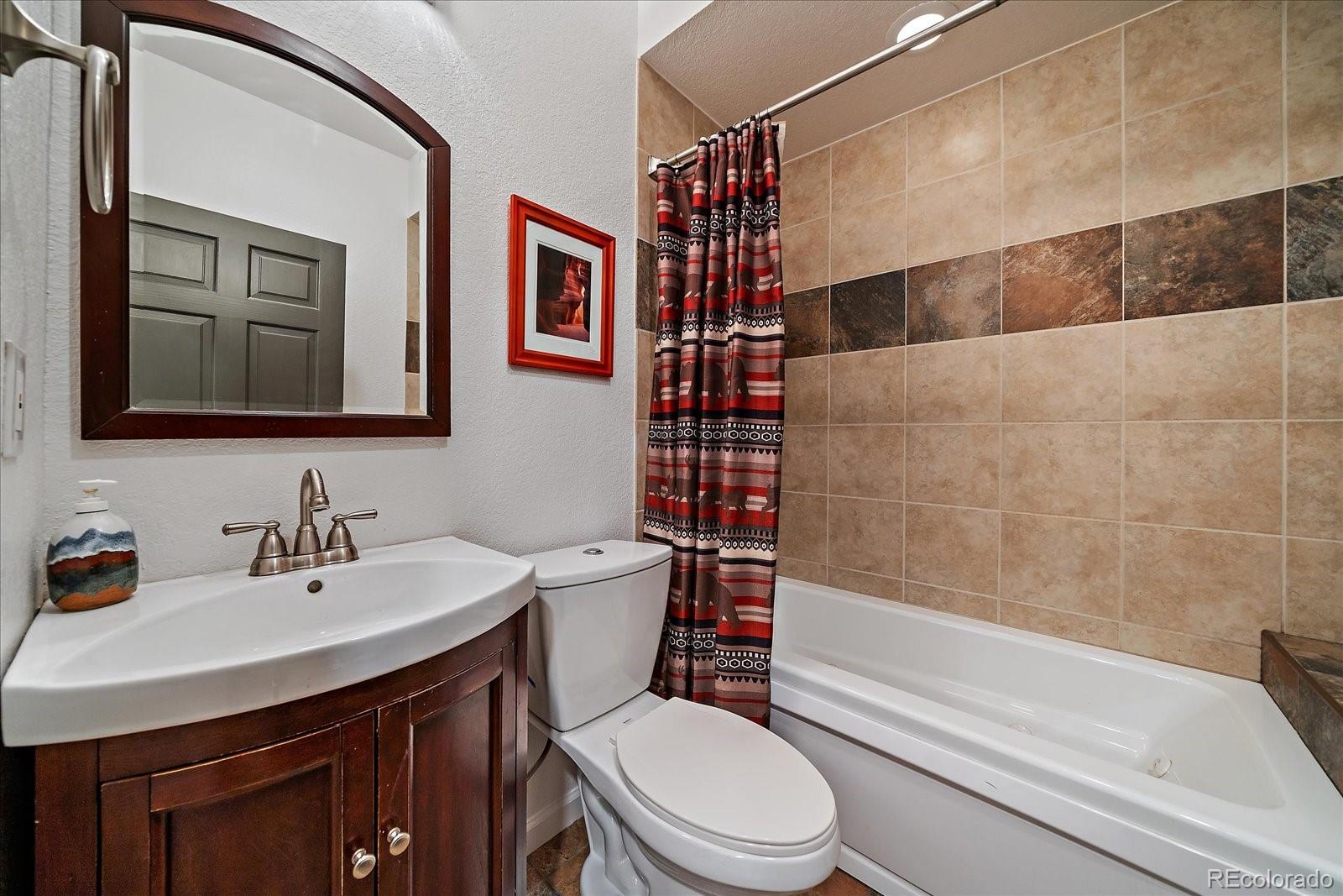 27756 Troublesome Gulch Road Evergreen, CO 80439 - Photo 35 of 47 a bathroom with a sink a toilet and shower