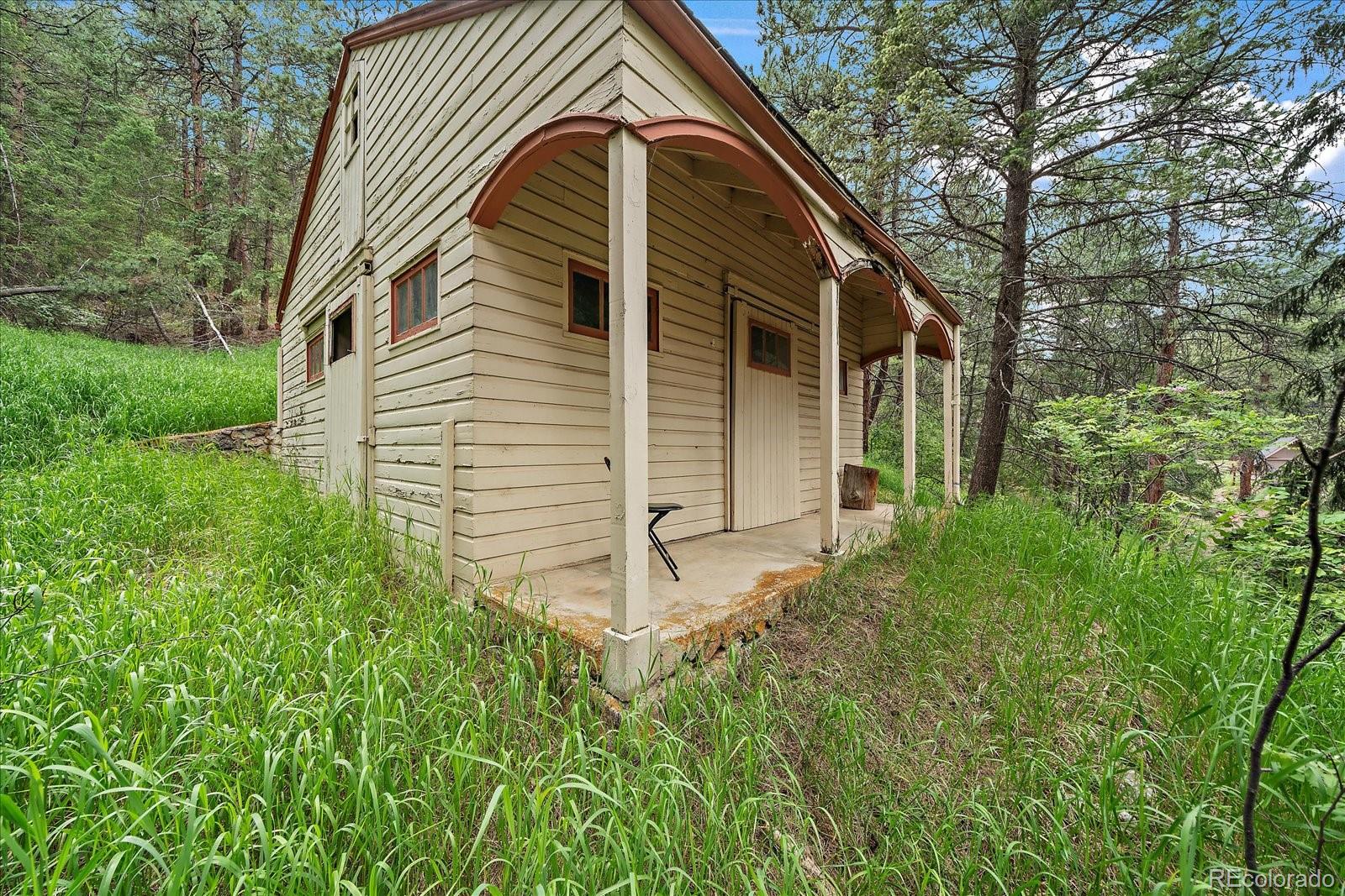 27756 Troublesome Gulch Road Evergreen, CO 80439 - Photo 37 of 47 a view of a house with a yard