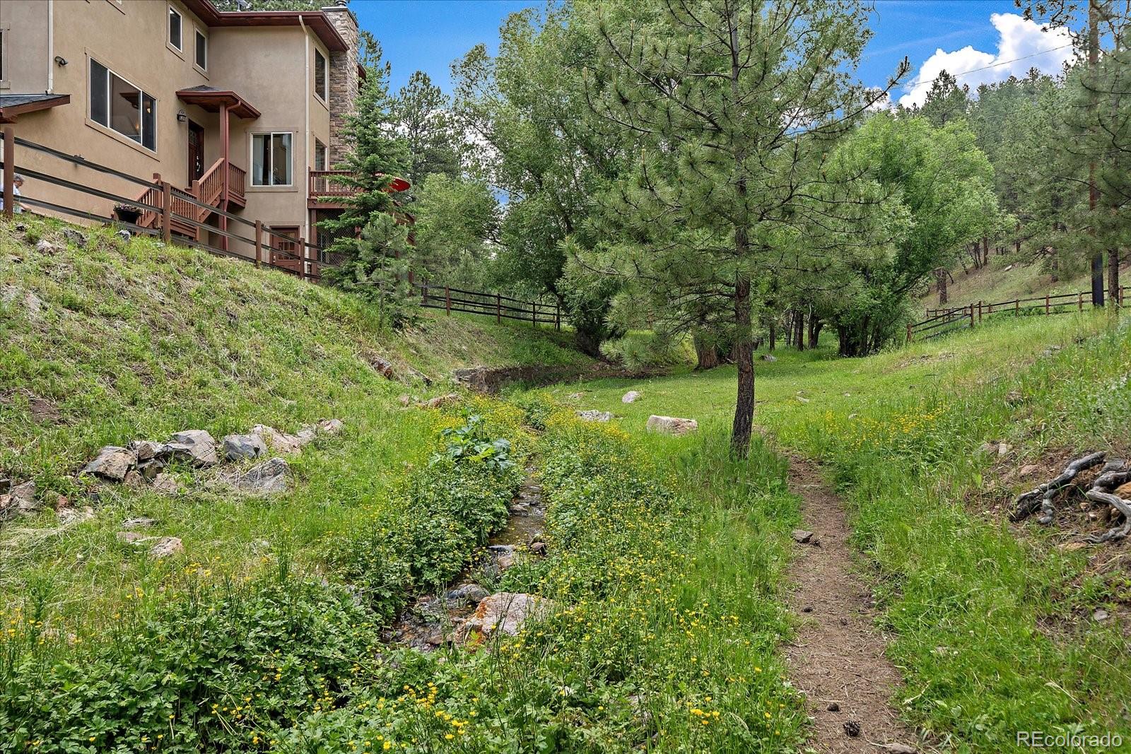 27756 Troublesome Gulch Road Evergreen, CO 80439 - Photo 44 of 47 a view of a garden with a house