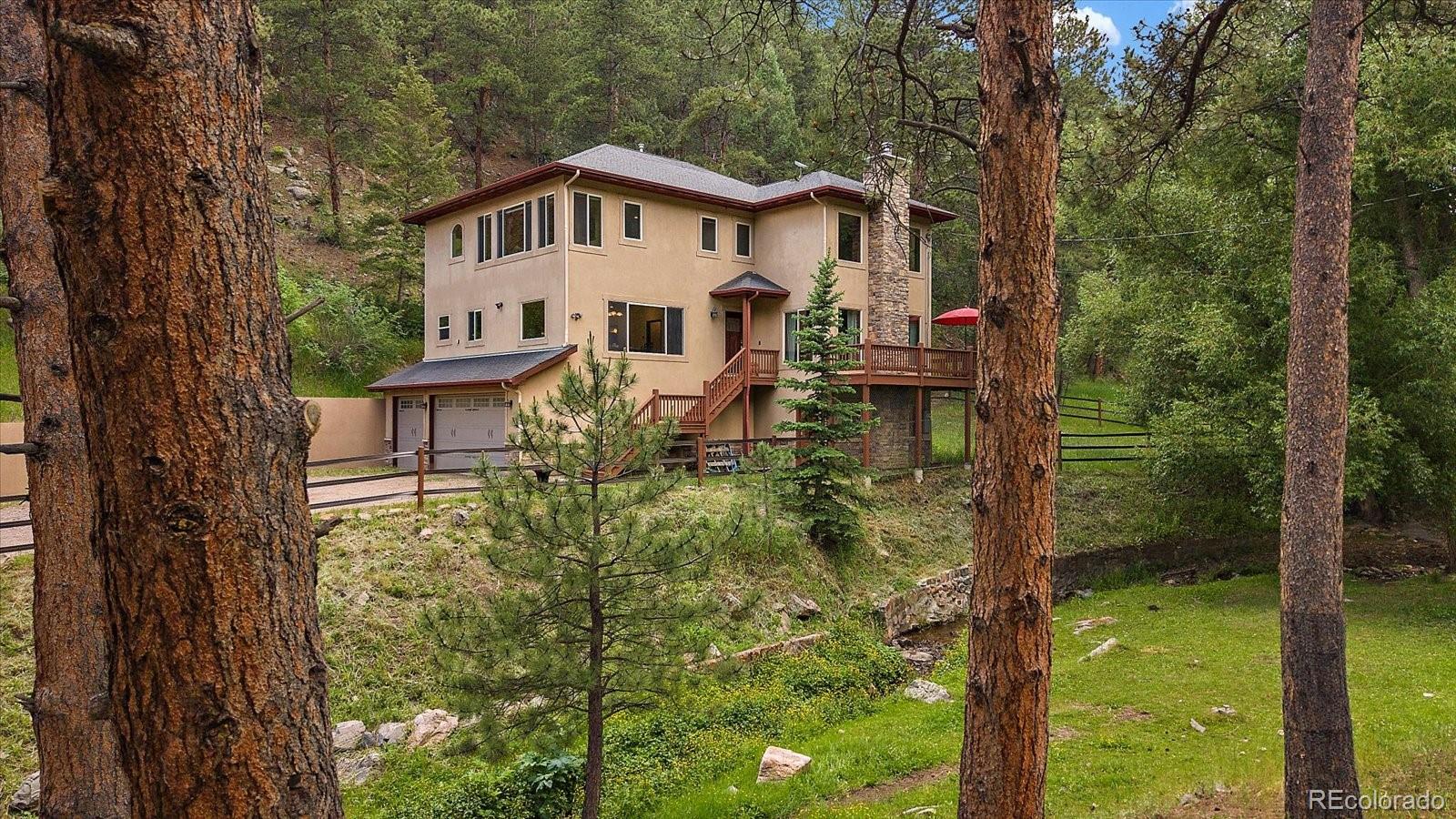 27756 Troublesome Gulch Road Evergreen, CO 80439 - Photo 9 of 47 a view of a house with a yard