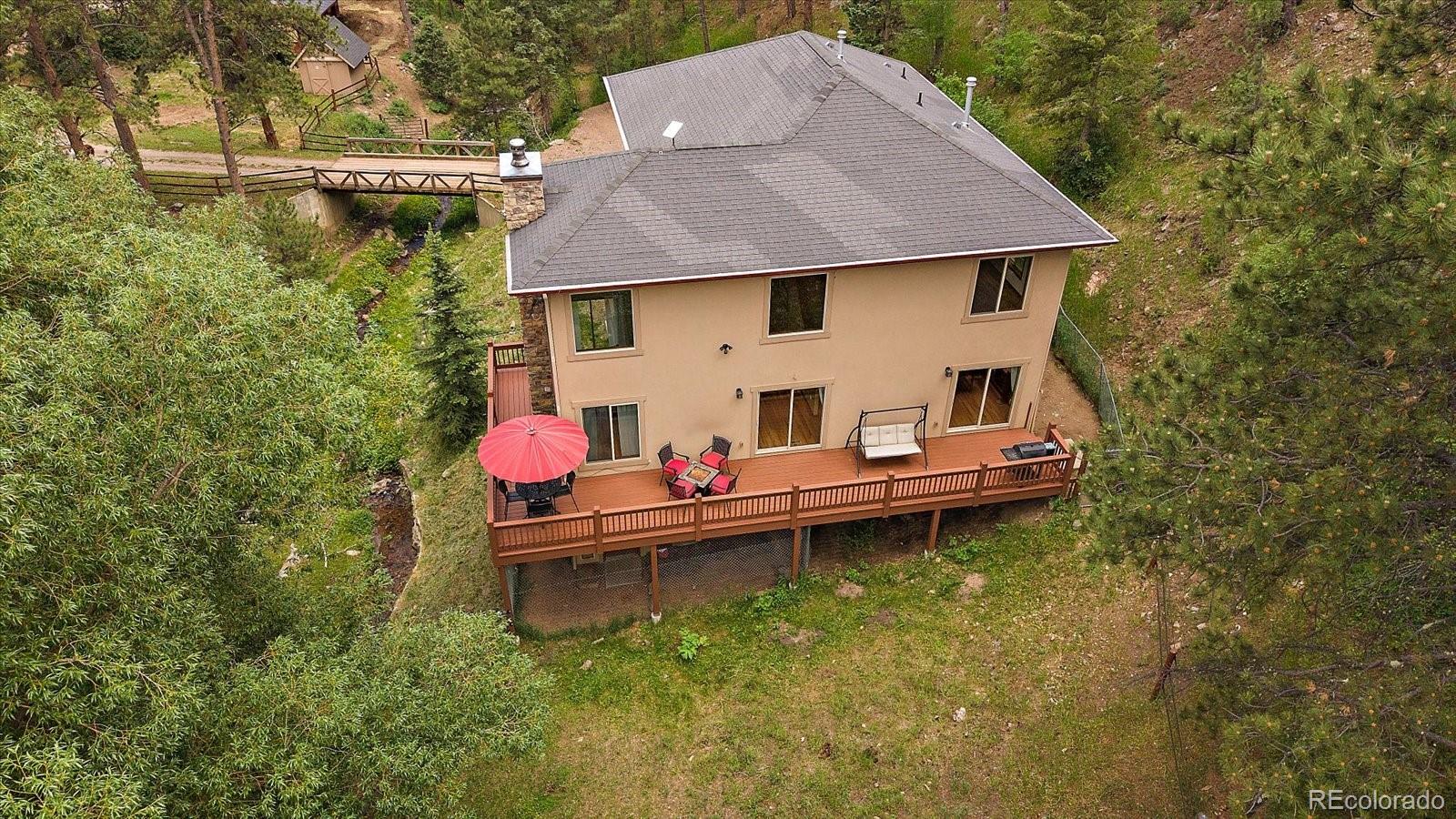 27756 Troublesome Gulch Road Evergreen, CO 80439 - Photo 10 of 47 a aerial view of a house with swimming pool and sitting area