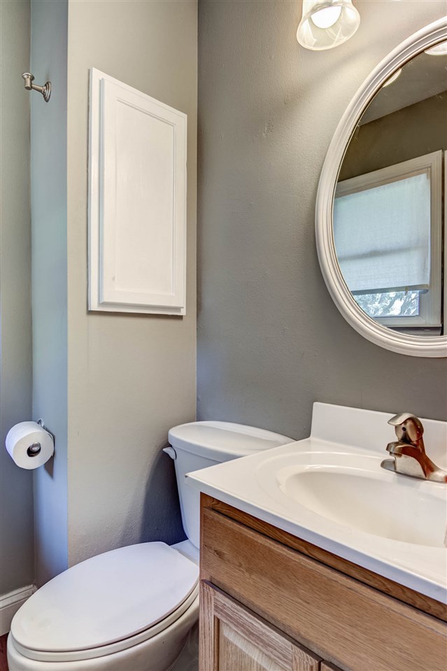 5981 Whitecliff Road Rockford, IL 61109 - Photo 13 of 25 a bathroom with a toilet a sink and mirror