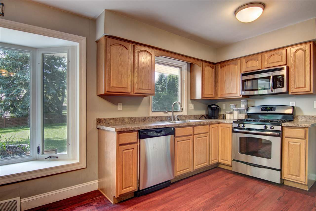 5981 Whitecliff Road Rockford, IL 61109 - Photo 7 of 25 a kitchen with granite countertop a stove a sink and a microwave