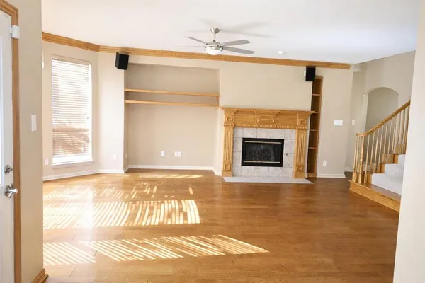 a view of an empty room with a fireplace and a window