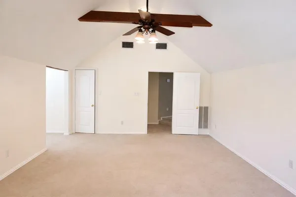 a view of an empty room with a ceiling fan