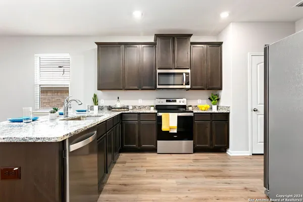 a kitchen with stainless steel appliances granite countertop a refrigerator sink and stove