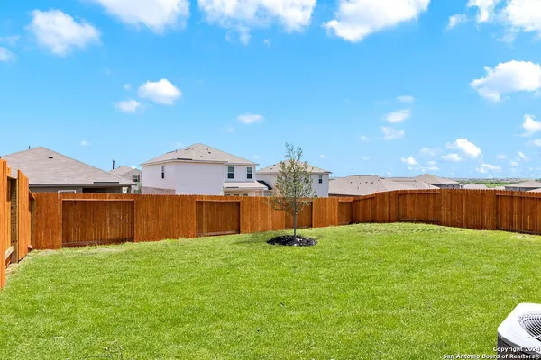 a front view of a house with a yard and fence