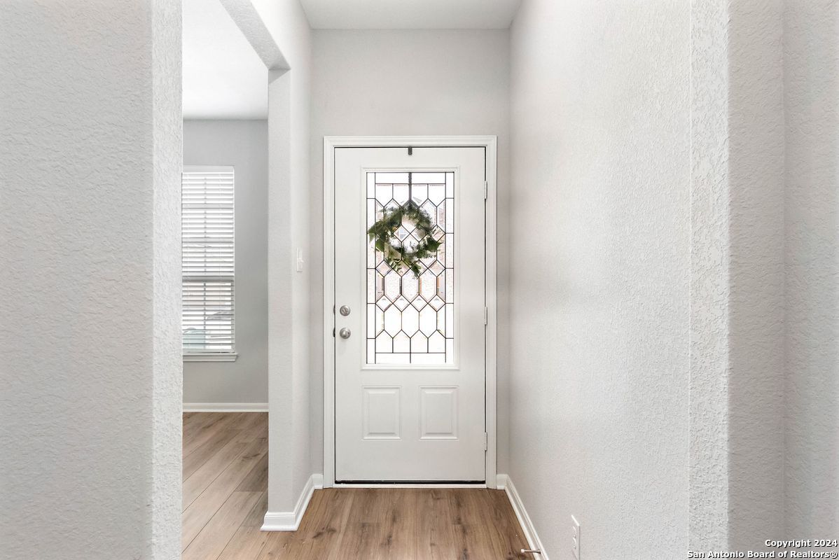 9219 Bennett Forest Converse, TX 78109 - Photo 4 of 23 an entryway to room with wooden floor mirror and windows