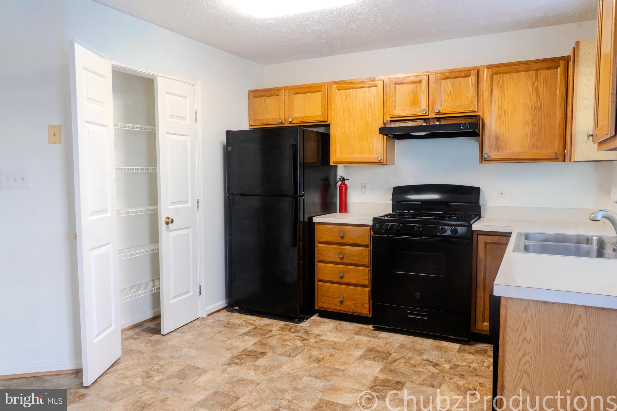 8316 Widgeon Place Laurel, MD 20724 - Photo 22 of 32 a kitchen with a refrigerator and a stove