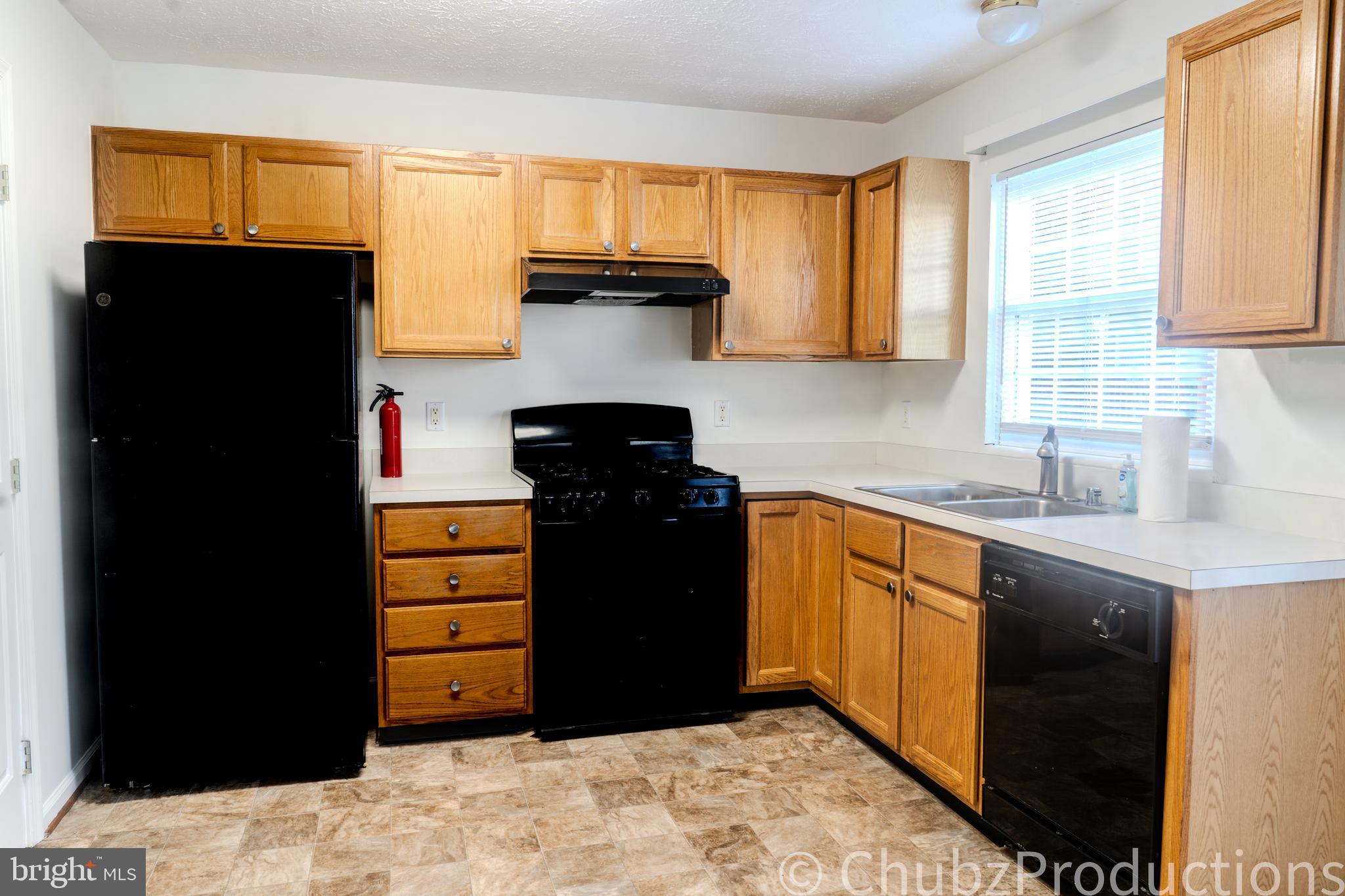8316 Widgeon Place Laurel, MD 20724 - Photo 23 of 32 a kitchen with stainless steel appliances kitchen island granite countertop a refrigerator a stove and a sink