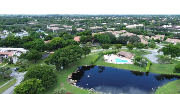 an aerial view of residential houses with outdoor space and trees
