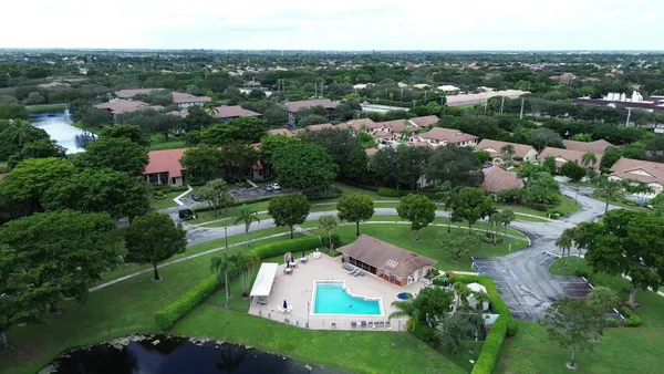 an aerial view of residential houses with outdoor space and trees