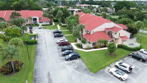 an aerial view of residential houses with outdoor space and parking