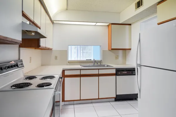 a kitchen with stainless steel appliances granite countertop a stove a refrigerator and a sink