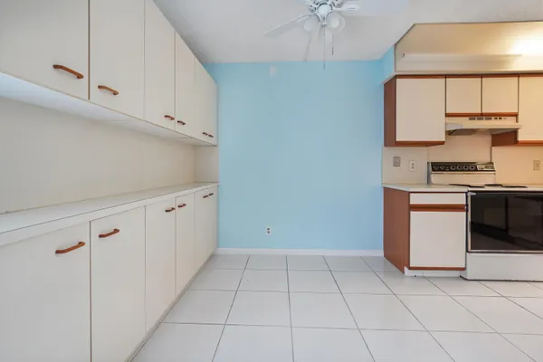 a kitchen with white cabinets and appliances