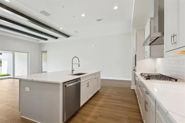 a kitchen with sink stove and cabinets