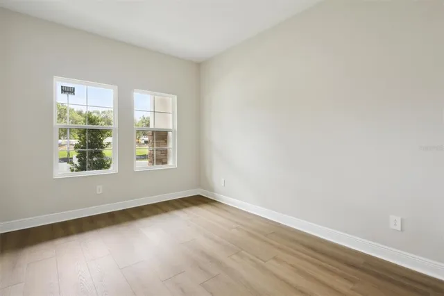 a view of an empty room with wooden floor