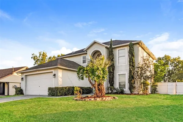 a front view of a house with a garden and yard